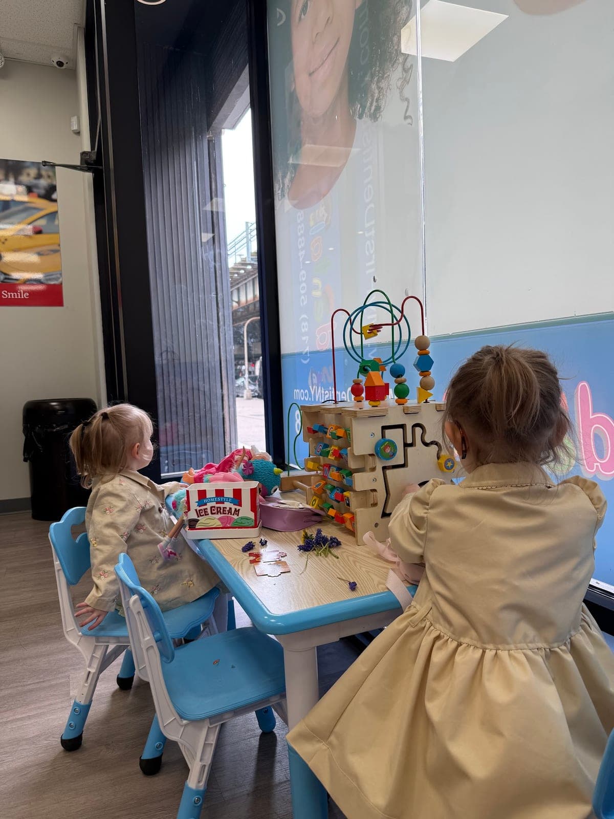 Toddlers playing at the waiting-room activity table